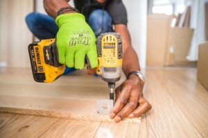 Paravent Intérieur : Expert en Séparation de Pièce & Design 170 Man using a power drill for home improvement on a wooden floor with precision.